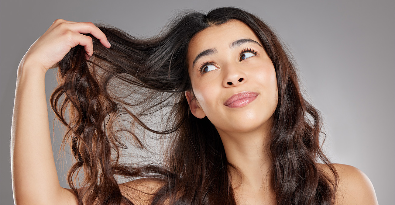 Giovane donna che guarda i capelli